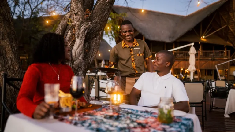 Evening time a man and lady having at a dinner table with a server