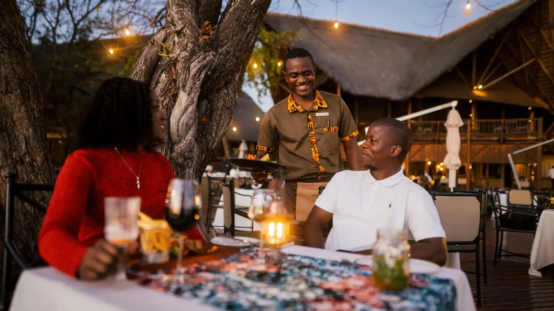 Evening time a man and lady having at a dinner table with a server